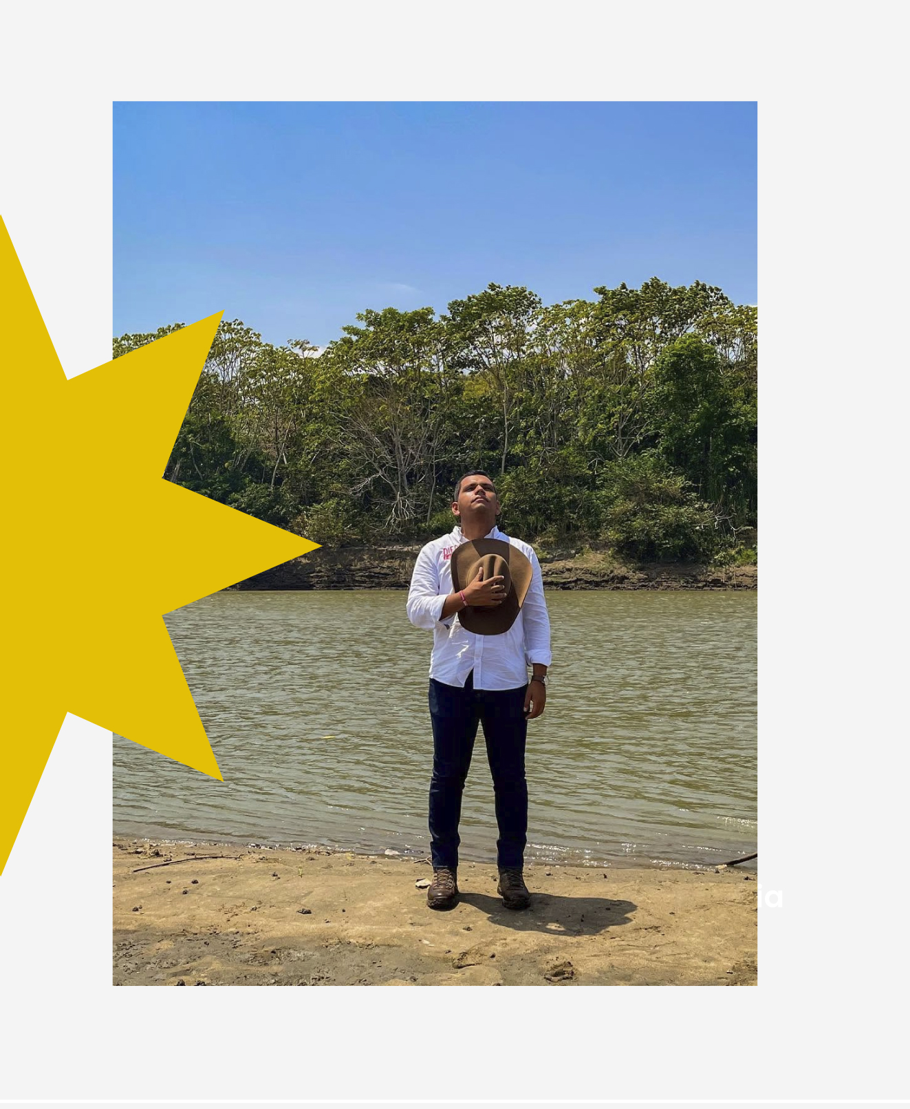 Diego García a orillas de un río en Casanare, sosteniendo un sombrero junto al pecho