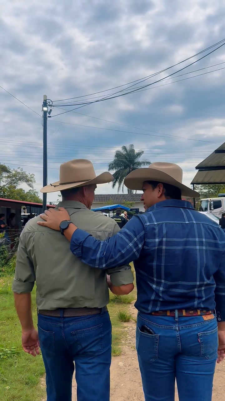 Diego García acompañando a un hombre con sombrero durante una jornada con las familias